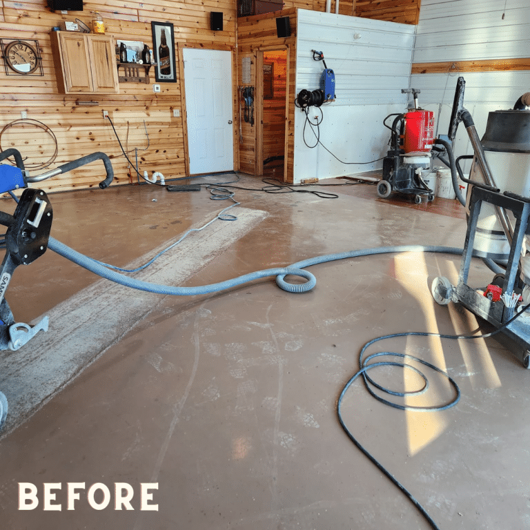 A photo of an unfinished concrete garage floor with cracks, chips, and other imperfections, ready for the application of an epoxy flake coating.