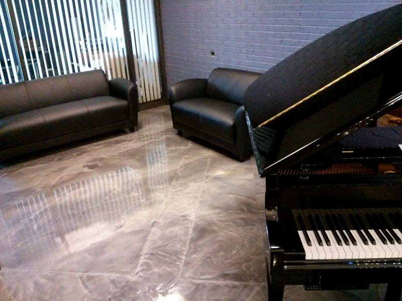 Image of a showroom floor with a Designer Epoxy flooring system. The flooring features a unique and intricate pattern with a glossy, reflective surface, providing a durable and attractive surface for showcasing products in a showroom setting.